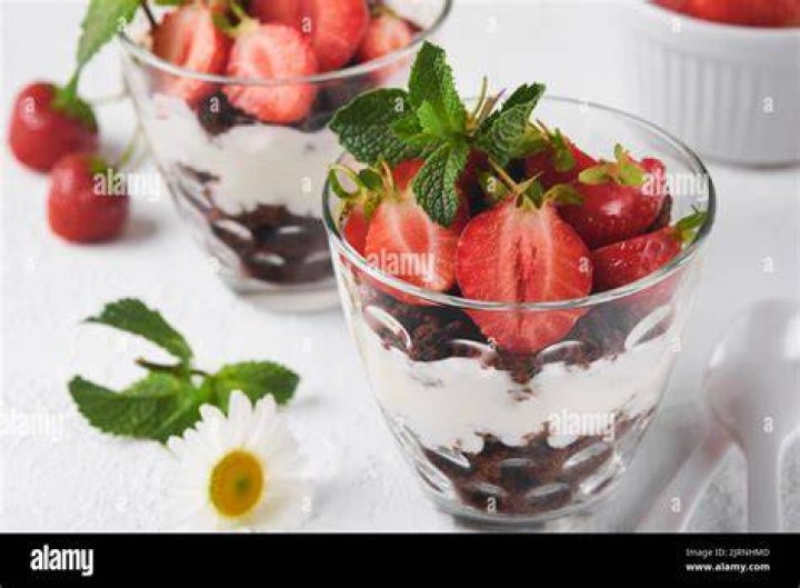 Glass with layers of brownies, whipped cream, and fudge sauce. 