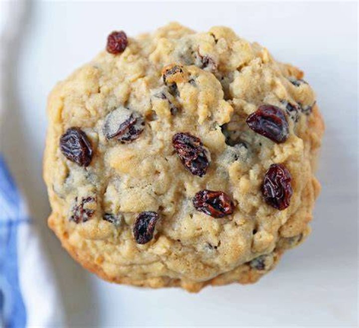 Oatmeal raisin cookies on a wooden plate.